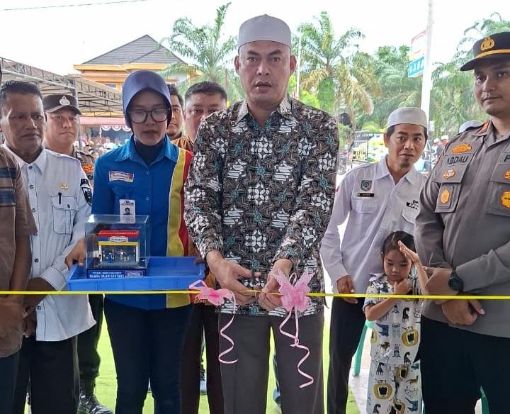 Anto Sontang menggunting pita tanda peresmian Gerai Indomaret di Desanya