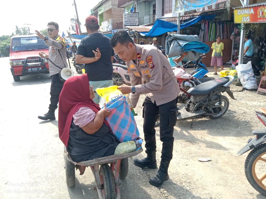 Kapolsek Rambah Samo IPDA Sarlose Mesra serahkan beras murah kepada salah seorang penyandang disabilitas