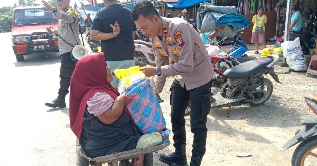 Kapolsek Rambah Samo IPDA Sarlose Mesra serahkan beras murah kepada salah seorang penyandang disabilitas